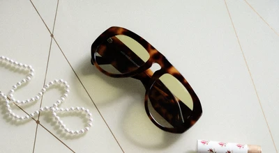 Buch und Sonnenbrille und Rose